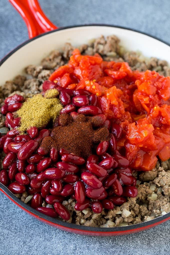 Ground beef, kidney beans, tomatoes and spices in a skillet.