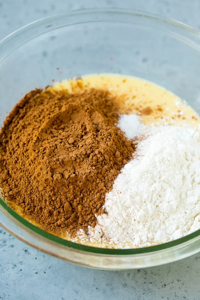 Cocoa powder and flour in a bowl of melted butter and sugar.