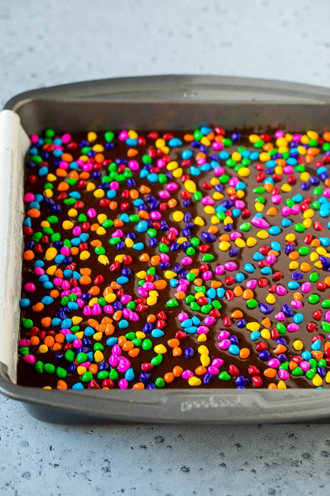 A pan of cosmic brownies with rainbow sprinkles on top.