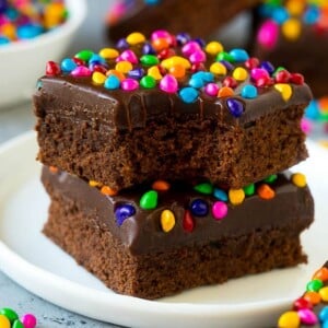 A stack of cosmic brownies on a plate with a bite taken out of one.