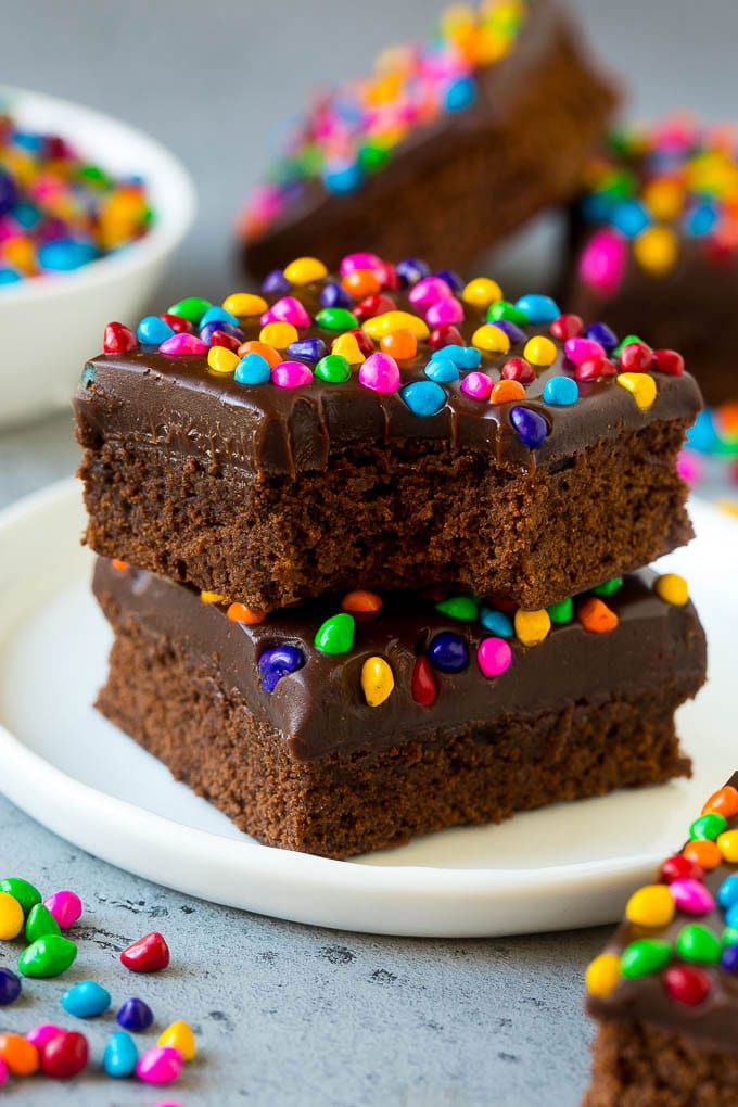 A stack of cosmic brownies on a plate with a bite taken out of one.