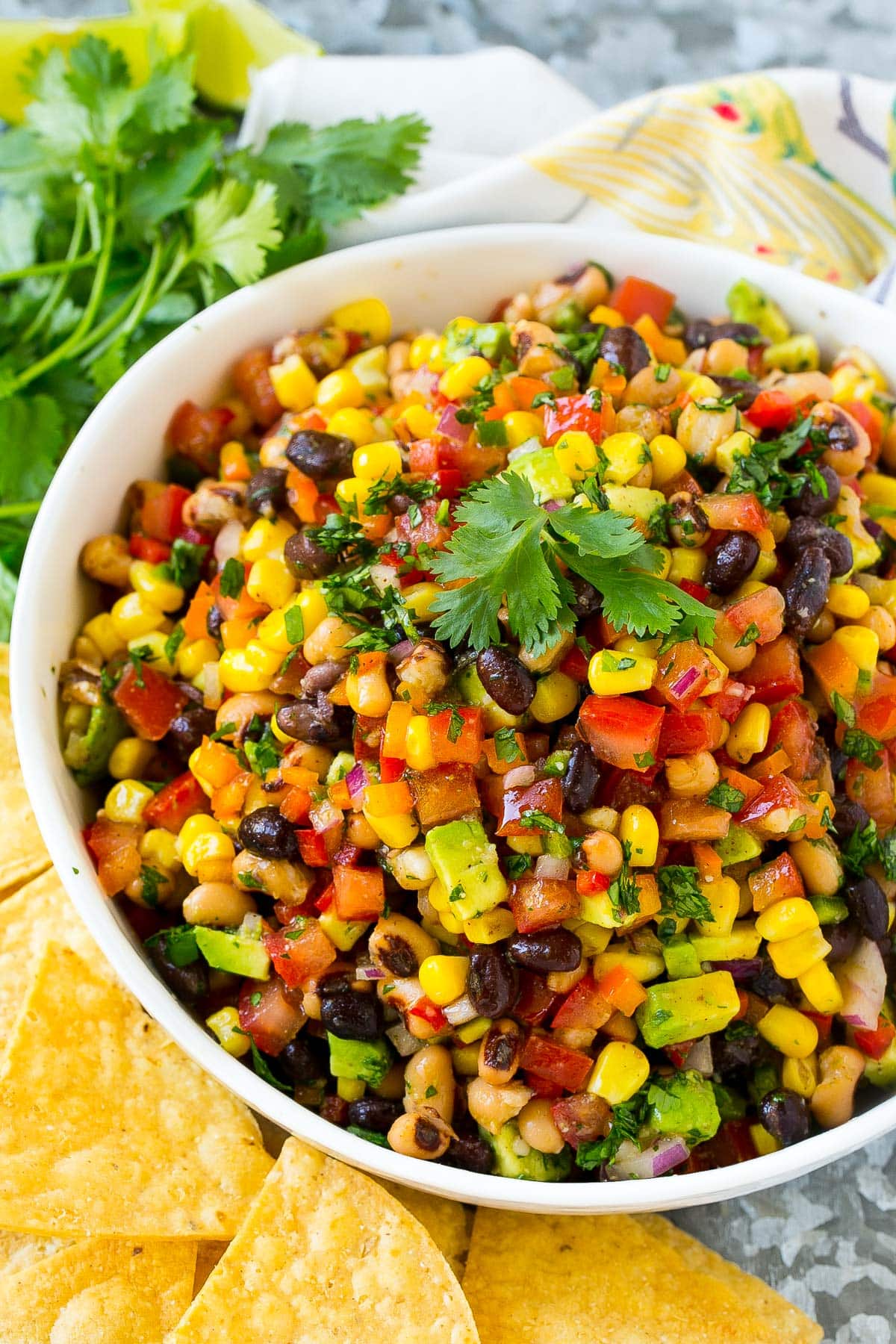 A bowl of cowboy caviar served with chips.