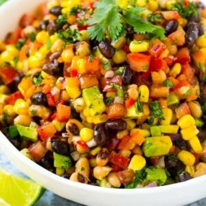 A serving bowl of cowboy caviar made with beans and veggies, and garnished with cilantro.