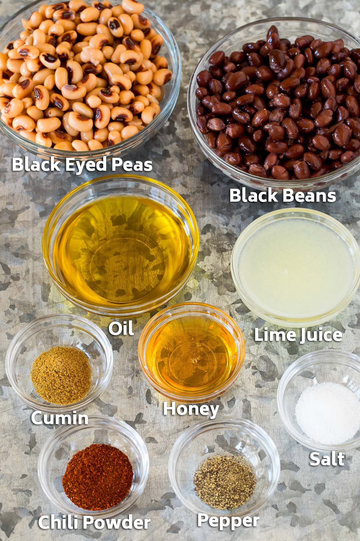 Bowls of beans, black eyed peas and salad dressing ingredients.