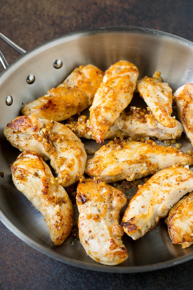 Chicken sauteed with garlic and butter in a skillet.