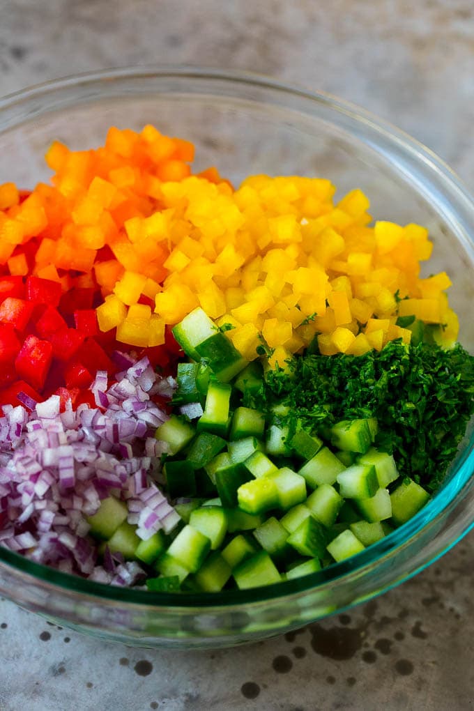 Chopped peppers, cucumbers, tomatoes and onions in a bowl.