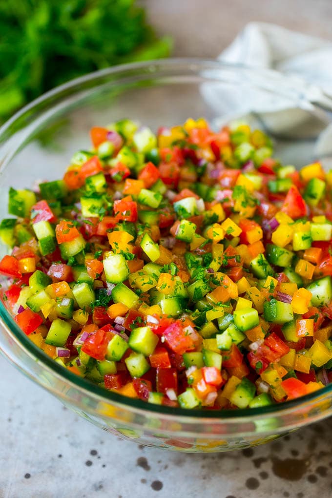 Israeli salad with cucumbers and tomatoes in a serving bowl.