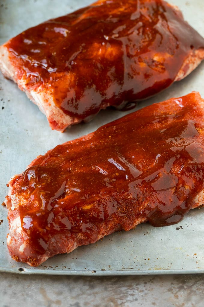 Two slabs of ribs coated in barbecue sauce.