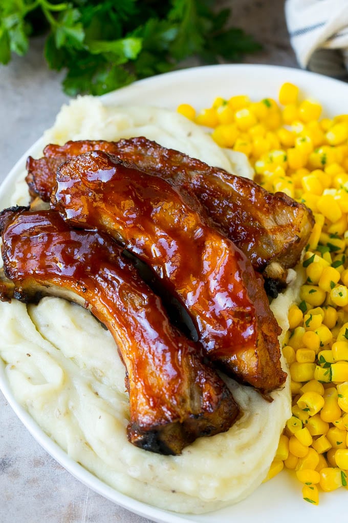 Slow cooker ribs served over mashed potatoes with corn.