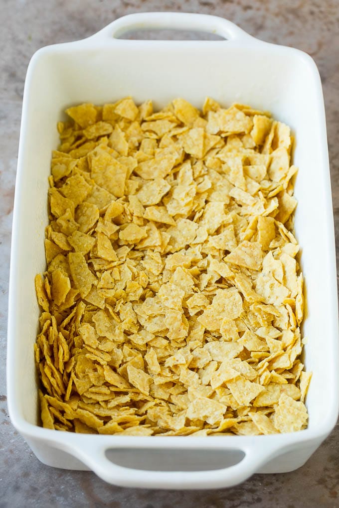 Crushed tortilla chips in a casserole dish.