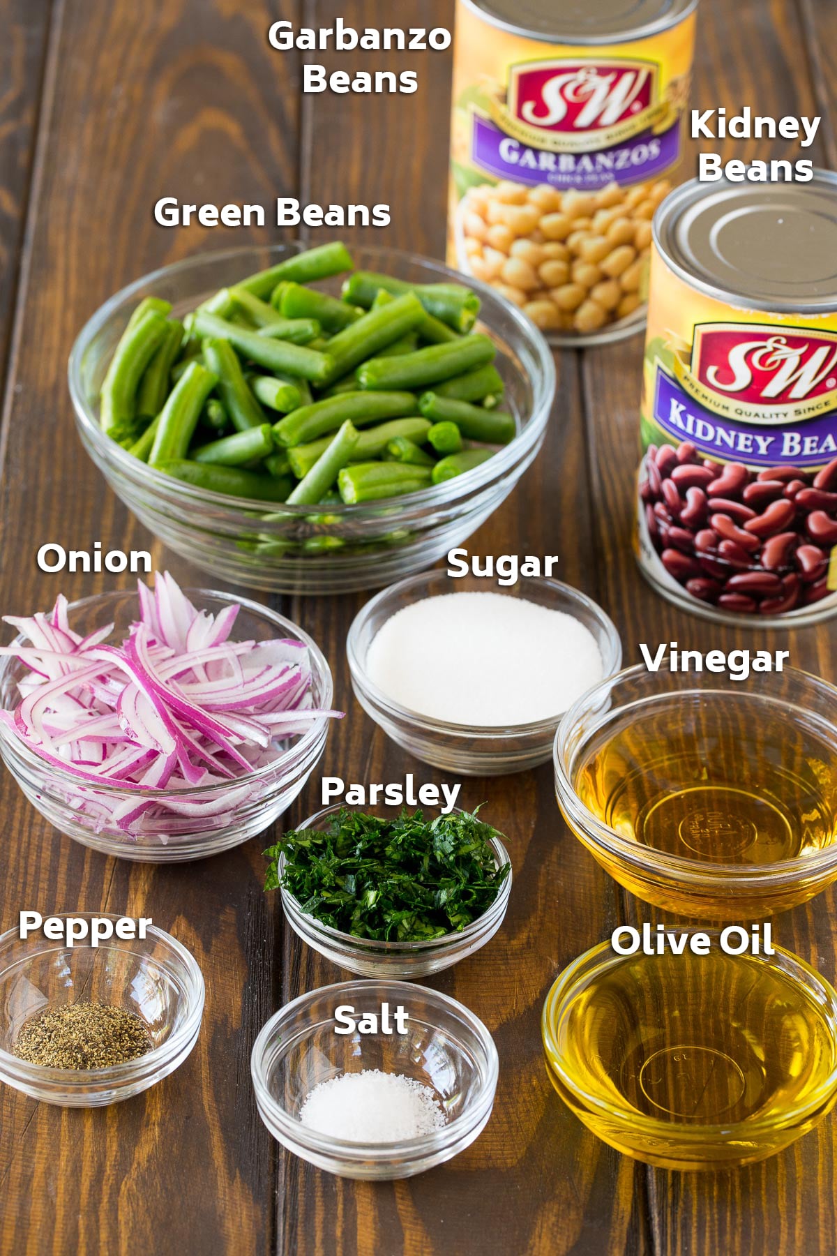 Ingredients including canned and fresh beans, olive oil, vinegar and seasonings.