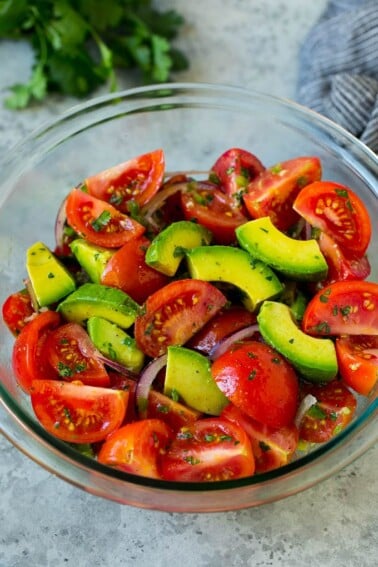 Tomato avocado salad with red onion and a cilantro lime dressing.