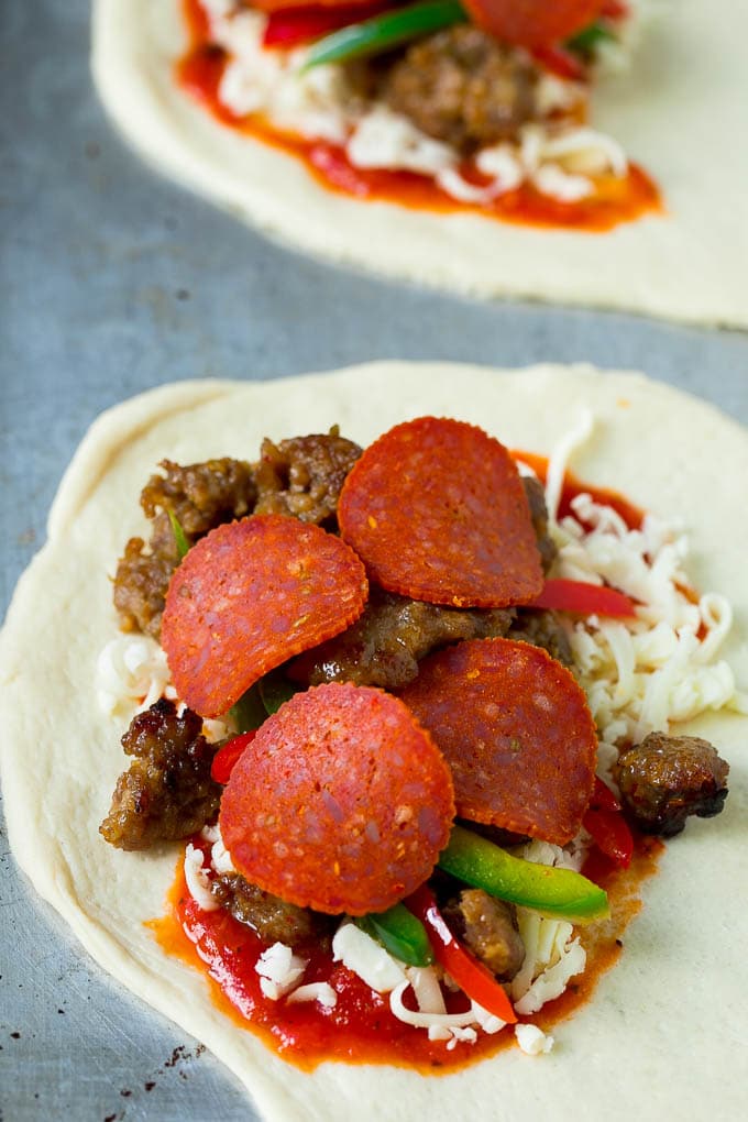 Pizza dough topped with sausage, pepperoni, peppers and cheese.