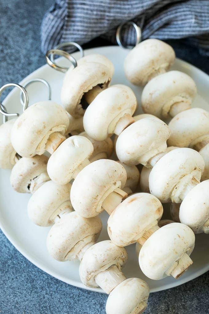 Mushrooms threaded onto skewers.