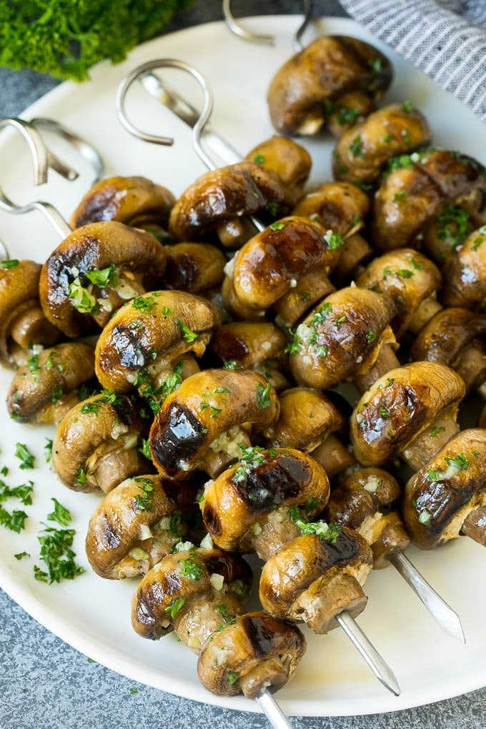 Grilled mushrooms on skewers topped with garlic butter.