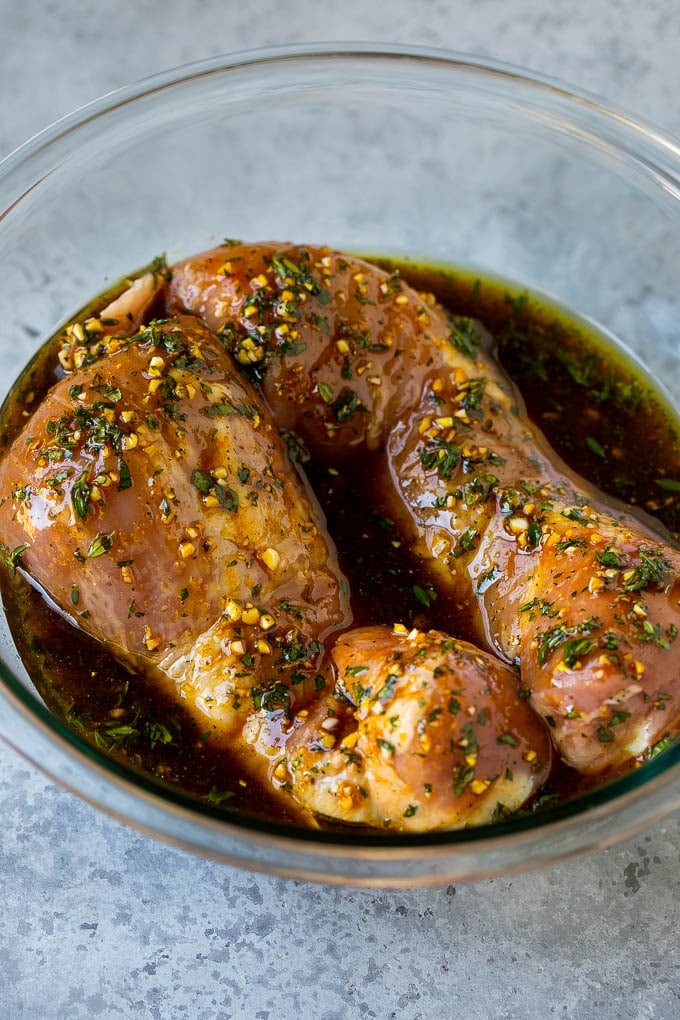 Pork tenderloins in a bowl of marinade.