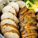 Pork tenderloin marinade with sliced cooked pork in a skillet.