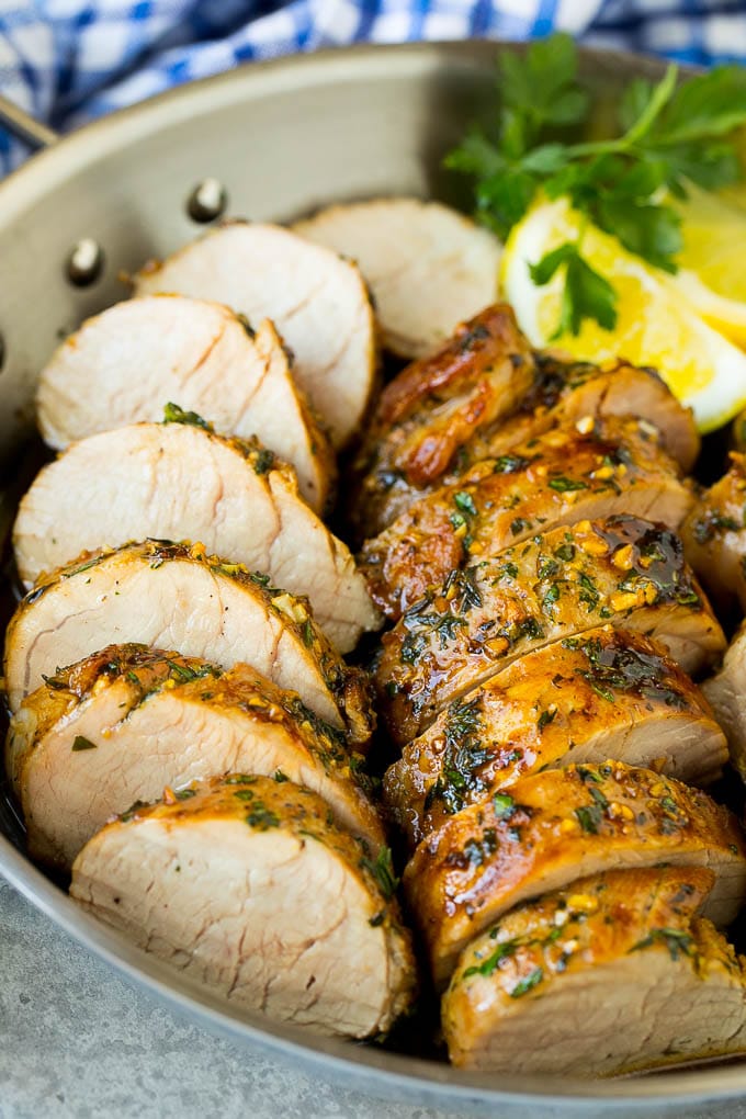 Pork tenderloin marinade with sliced cooked pork in a skillet.