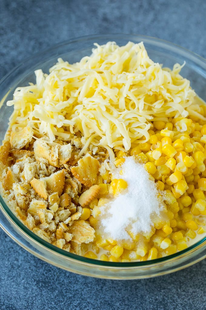 Scalloped Corn | Corn Casserole #corn #casserole #cheese #sidedish #dinner #dinneratthezoo Corn, crushed crackers, seasonings and shredded cheese in a bowl.