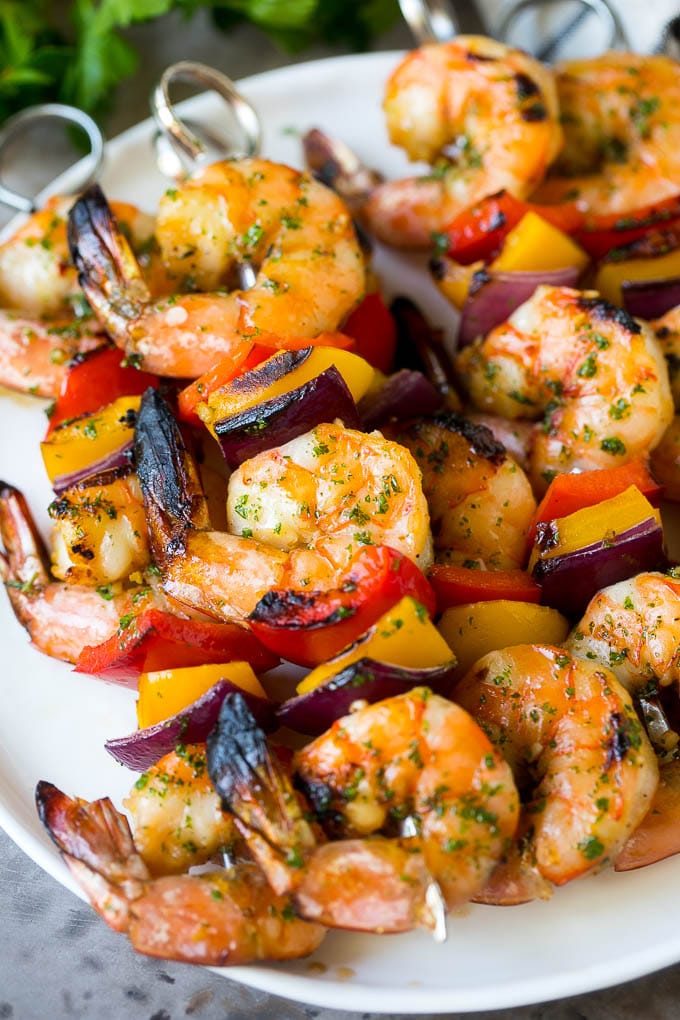 A plate of shrimp kabobs made with bell peppers and red onions.