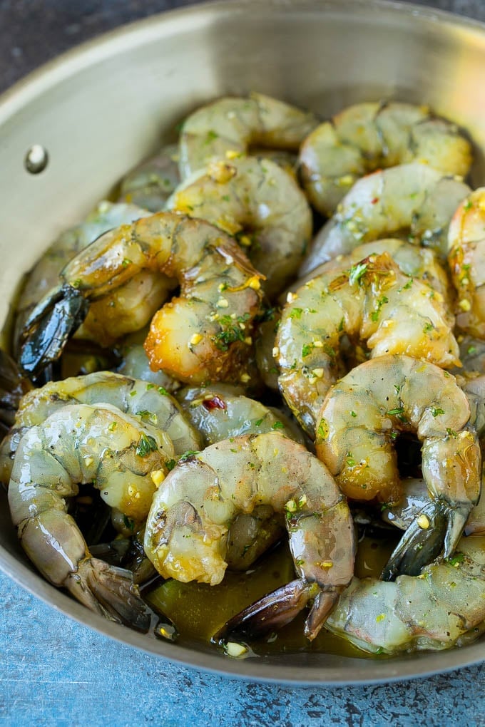 Raw marinated shrimp in a skillet.