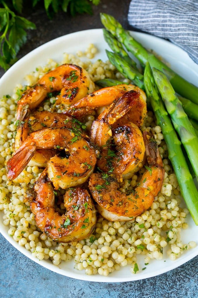 Shrimp marinade over cooked shrimp with asparagus and couscous on the side.