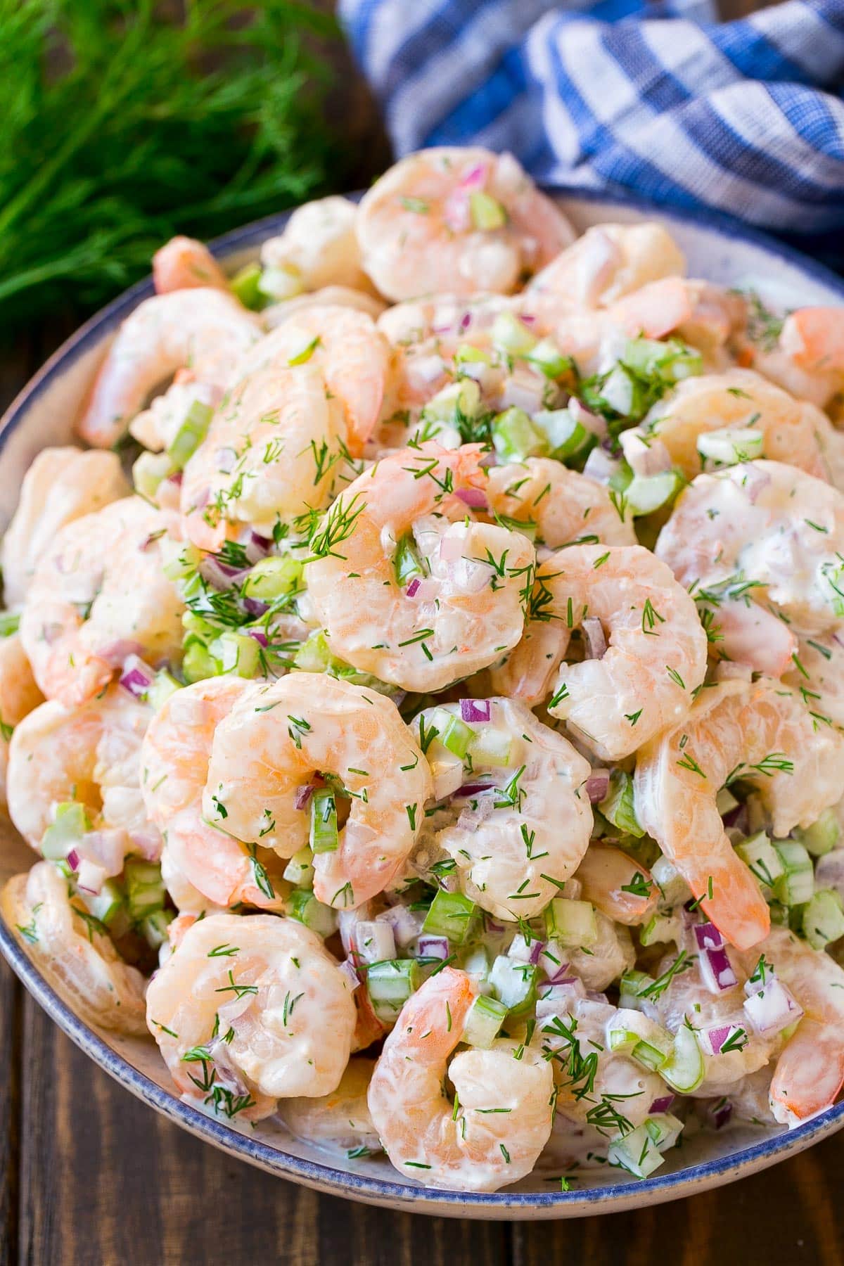 Shrimp salad in a serving bowl, topped with fresh dill.