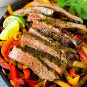 Steak fajitas served on a bed of seared peppers and onions.