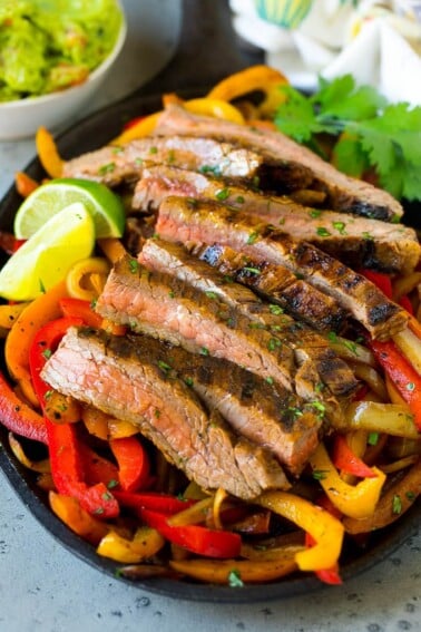 Steak fajitas served on a bed of seared peppers and onions.