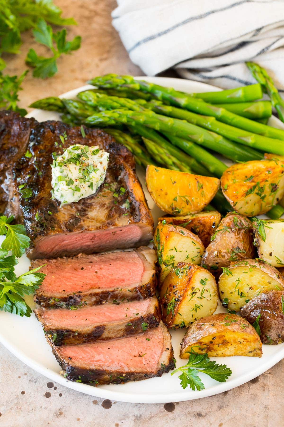 Beef in a steak marinade that's been grilled and sliced and served with potatoes and vegetables.