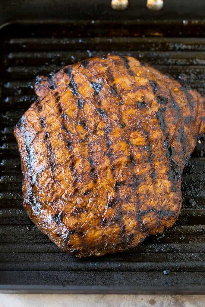 Grilled flank steak in a pan.