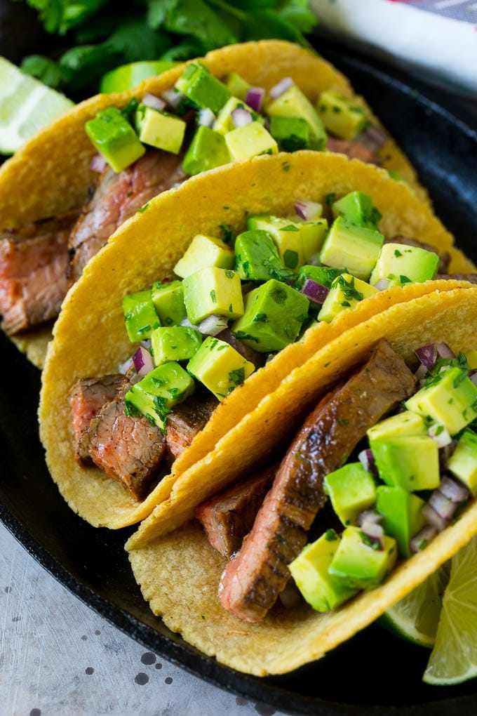 A platter of grilled steak tacos in corn tortillas.