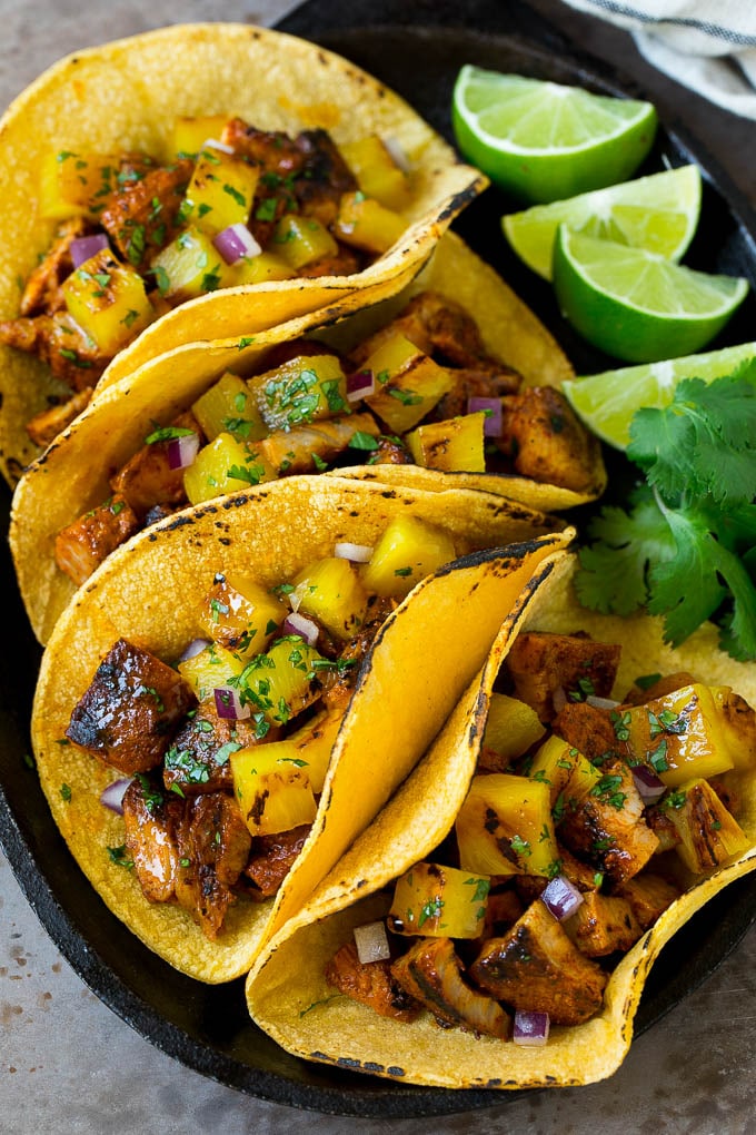Tacos al pastor filled with marinated pork and pineapple.