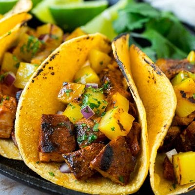 Tacos al pastor stuffed with grilled pork, pineapple, red onion and cilantro.