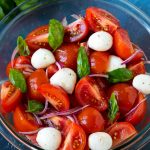 Tomato salad with fresh mozzarella cheese, red onion and basil.
