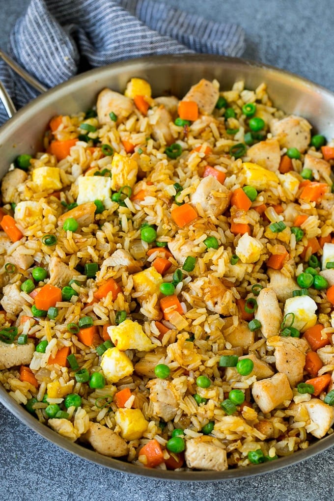 A pan of chicken fried rice with eggs and vegetables.