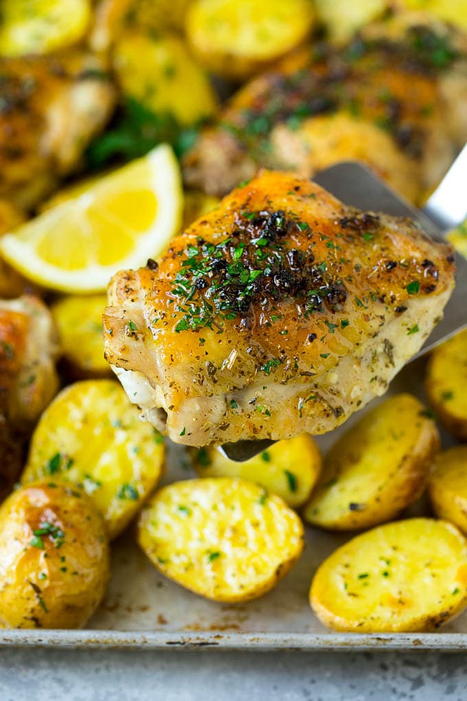 A spatula serving a piece of Greek chicken thighs.