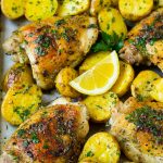 A sheet pan of Greek chicken and potatoes with garlic, herbs and lemon.