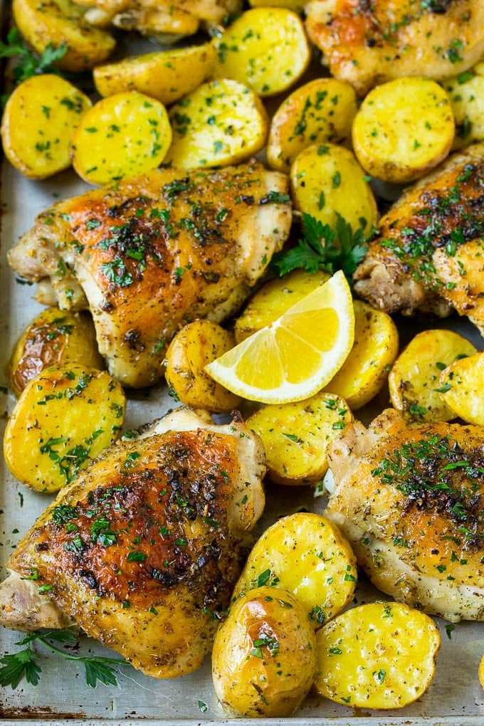A sheet pan of Greek chicken and potatoes with garlic, herbs and lemon.