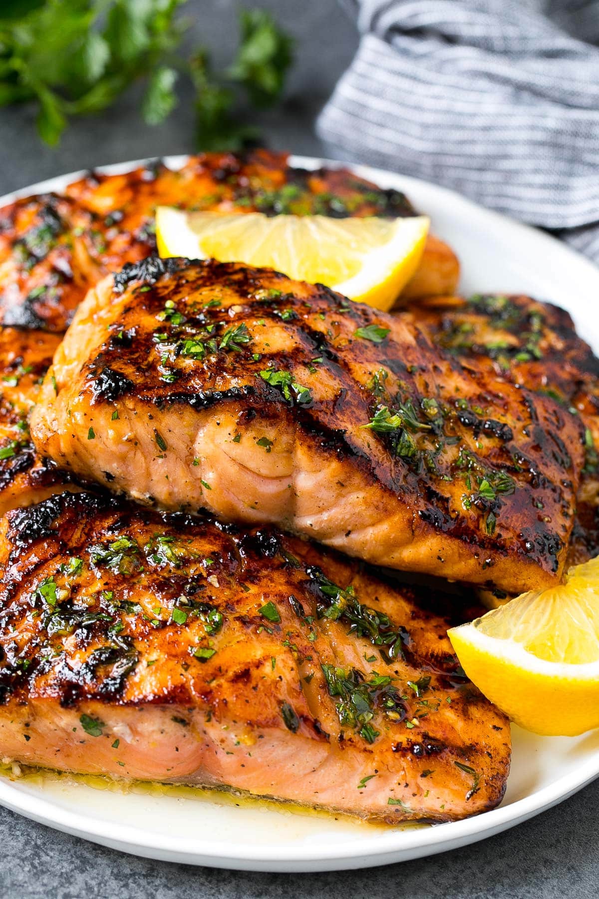 Grilled salmon on a plate with lemon wedges on the side.