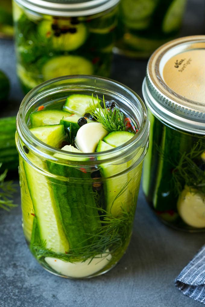 A jar of refrigerator pickles with cucumber spears, garlic and dill.