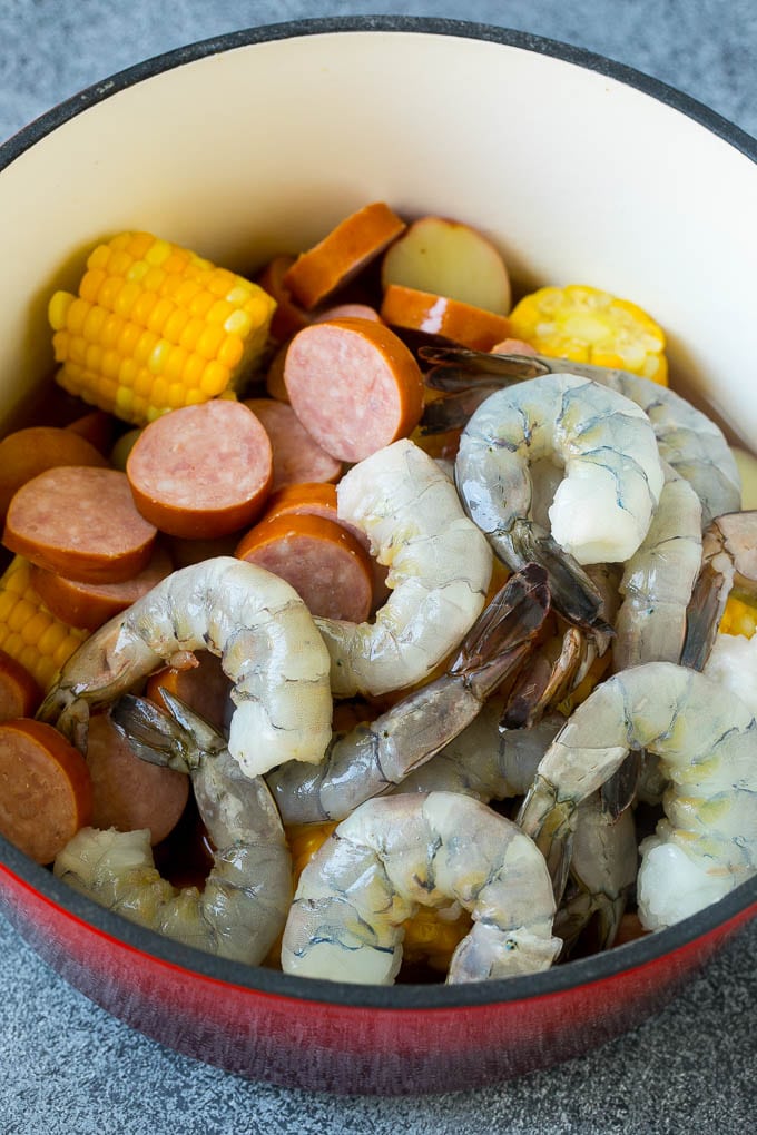 Sausage, shrimp, corn and potatoes in a red pot.