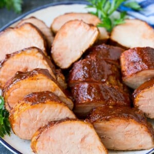 Smoked pork tenderloin sliced on a serving plate.