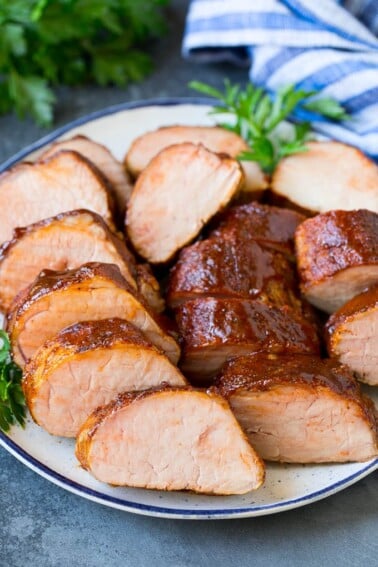 Smoked pork tenderloin sliced on a serving plate.