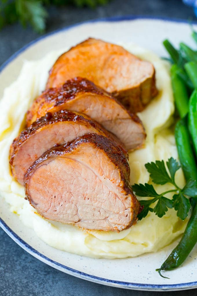 Sliced smoked pork tenderloin served with mashed potatoes and vegetables.