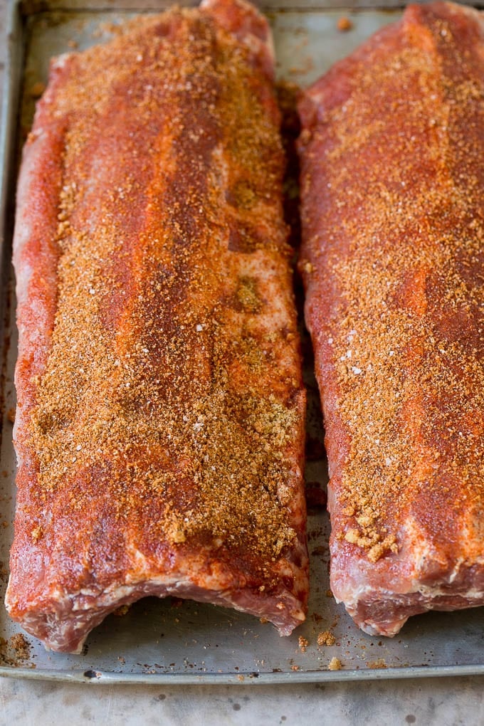 Two racks of ribs coated in spice rub.