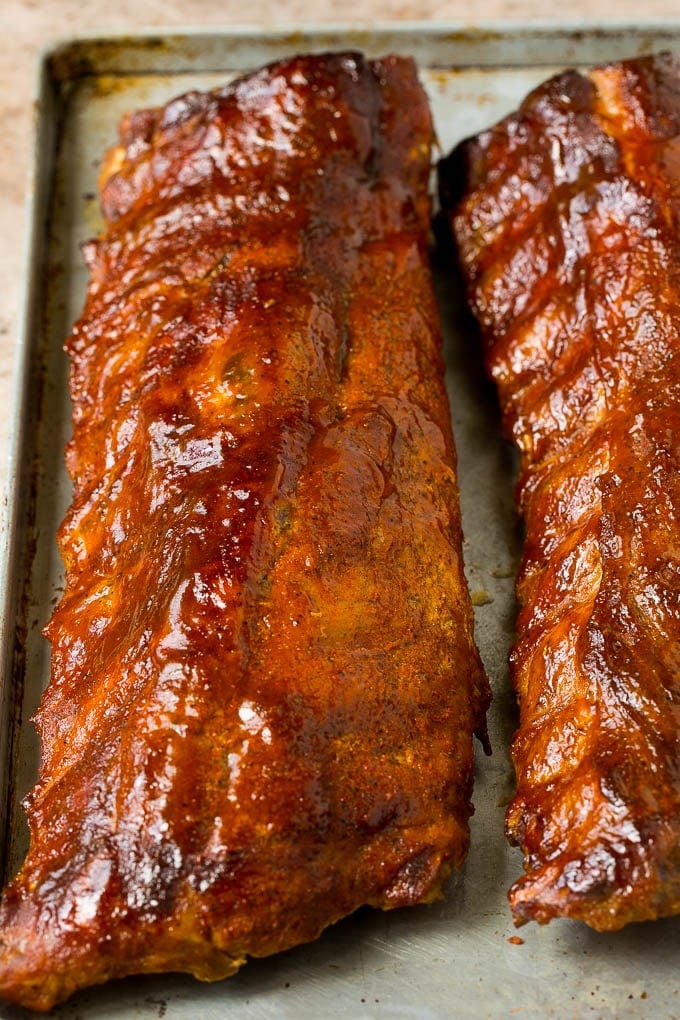 Racks of smoked ribs coated in BBQ sauce.