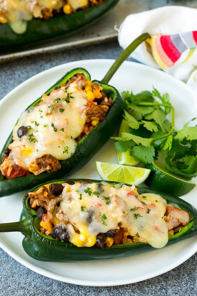 A plate of stuffed poblano peppers topped with melted cheese.
