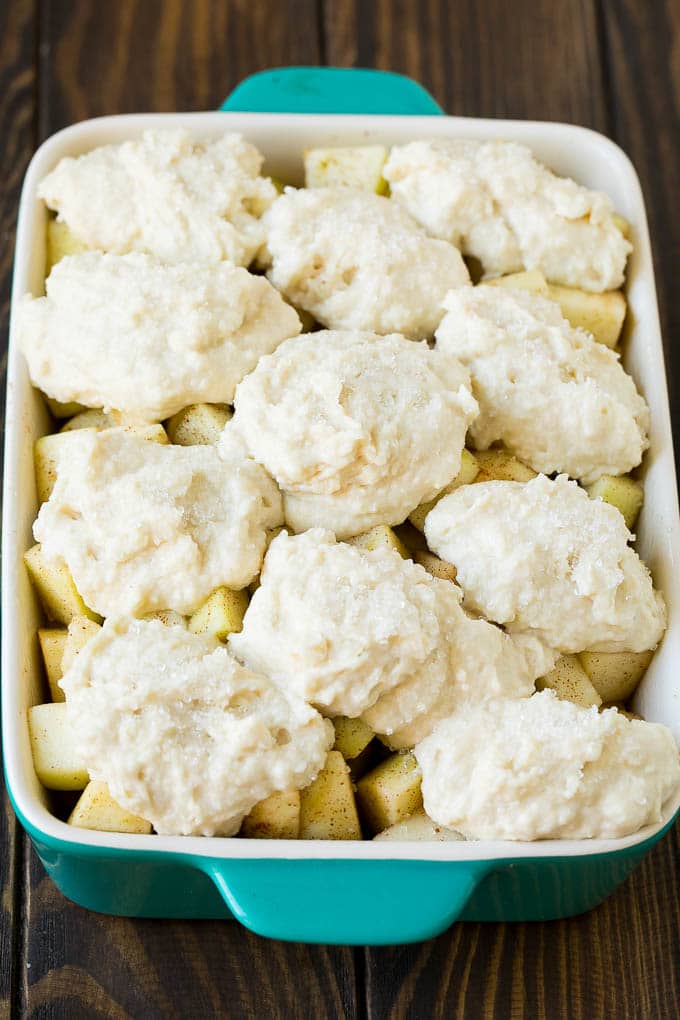 Fruit in a baking dish with dough over the top.