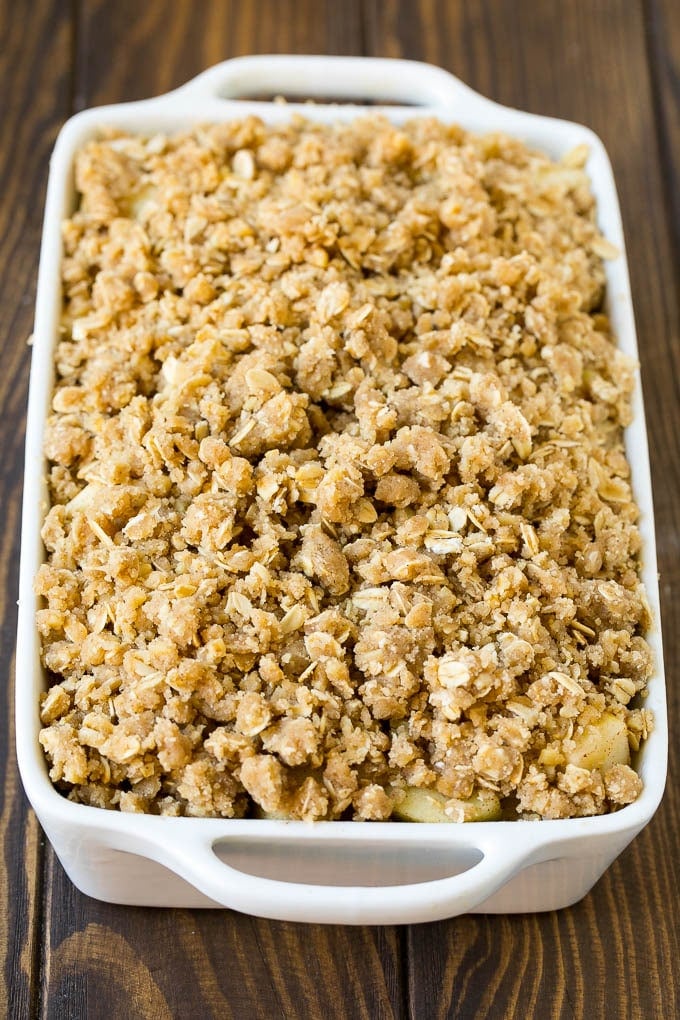 Apples in a baking dish topped with brown sugar crumble.